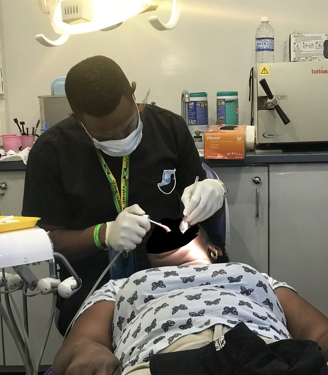 FLOSS Jamaica clinician examining patient during community health fair